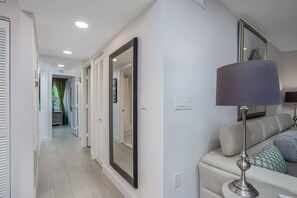 Una sala de estar moderna con un sofá, una lámpara y un espejo grande.