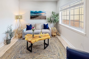 A living room with a sofa, coffee table, and decorative items. - Beach Club Modern Condo C Bldg (Siesta Key)