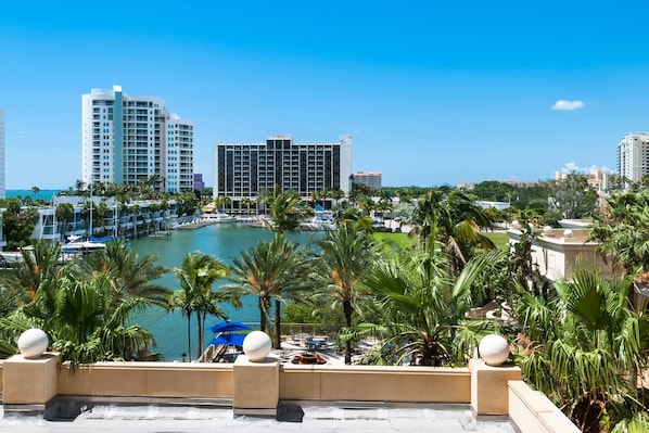 A waterfront hotel with a marina, palm trees, and high-rise buildings in the background. - Vista Hermosa A Few Steps to the Heated Pool (Siesta Key)