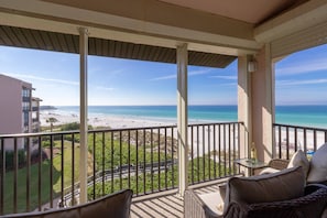 A balcony with a view of a beach and ocean.