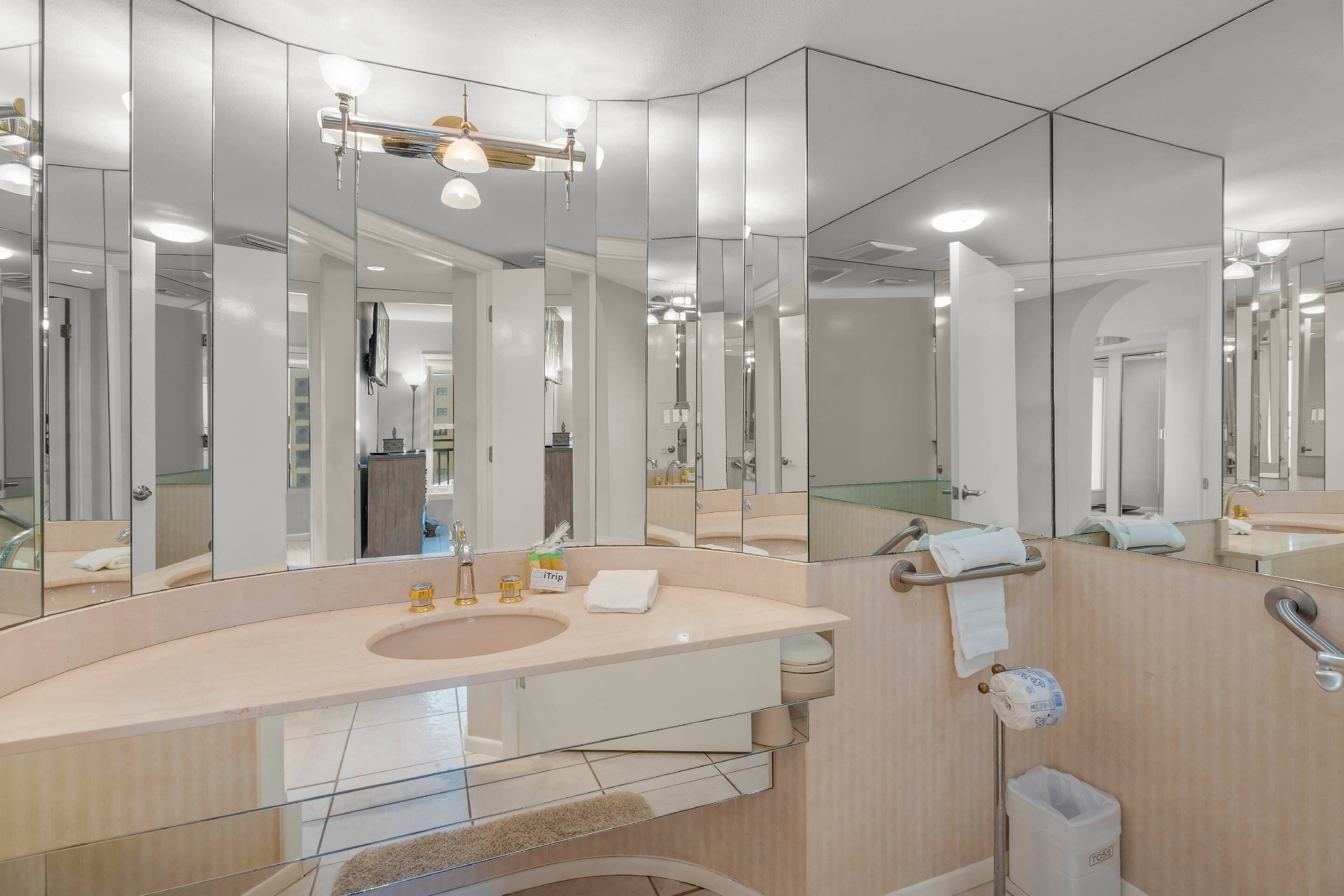 Une salle de bain moderne avec un grand miroir, un lavabo et des toilettes.