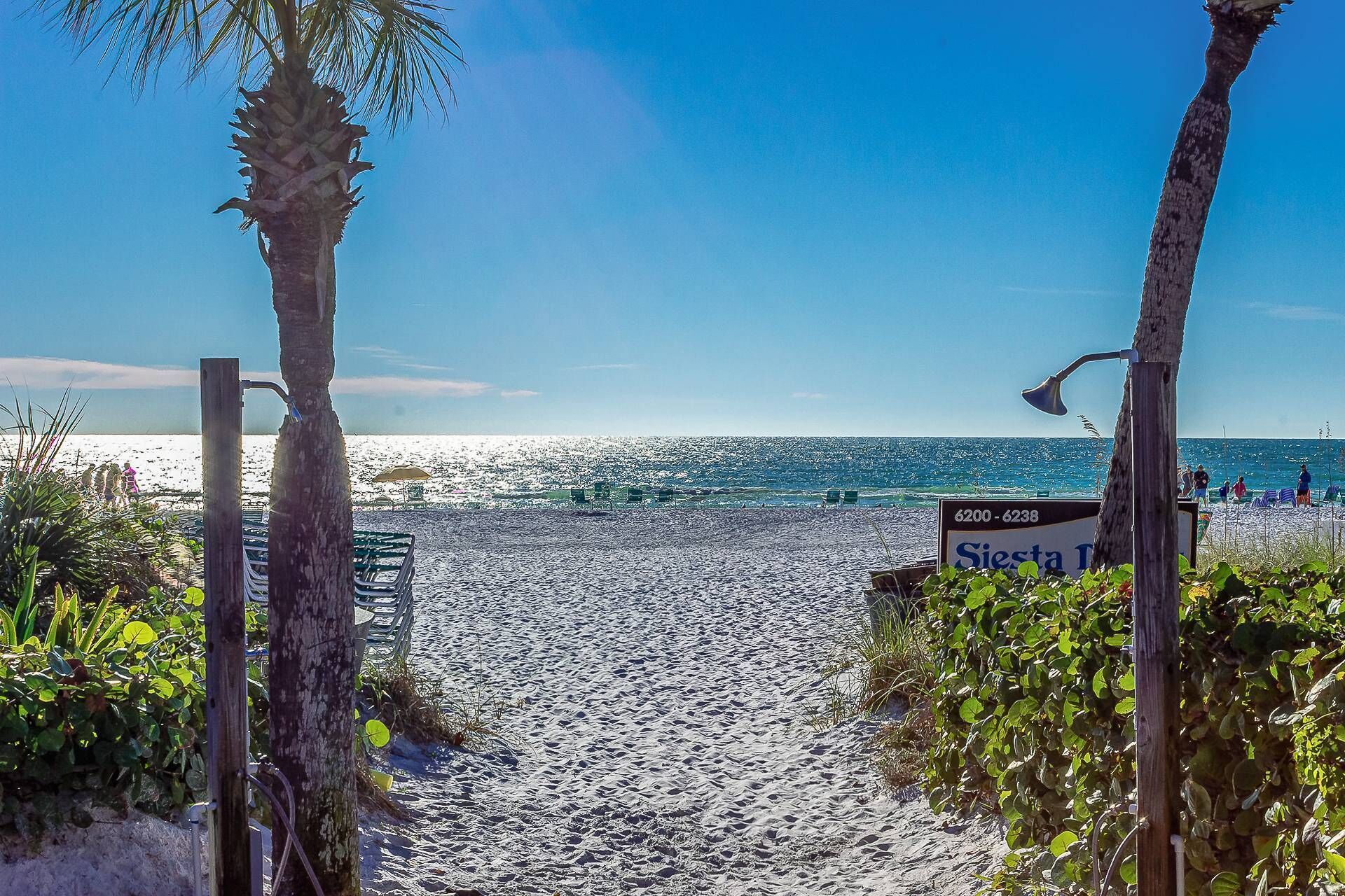 Ein Strand mit einem Schild für 'Siesta Inn' und einem Bereich mit Liegestühlen.