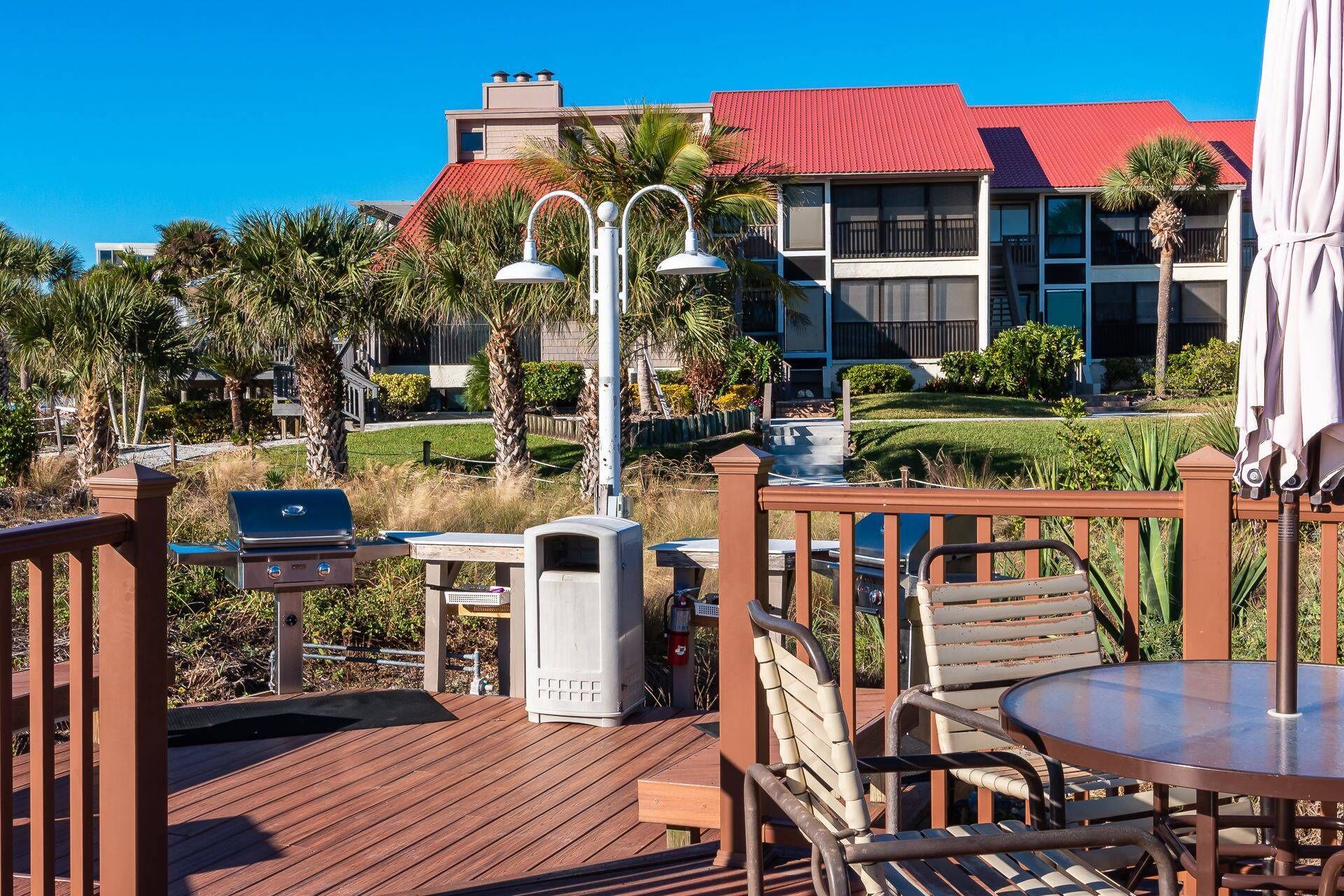 A deck with outdoor furniture, a grill, and a water fountain.