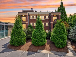 A multi-story residential building with a brick facade, multiple windows, and a rooftop terrace.