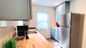 A modern kitchen with a stainless steel refrigerator, wooden countertops, and a built-in stove. - 2 KING 3 QUEEN BEDS. Spacious. Quiet Neighborhood (Euclid)
