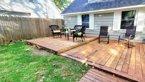 A wooden deck with outdoor furniture, a grassy yard, and a wooden fence. - 2 KING 3 QUEEN BEDS. Spacious. Quiet Neighborhood (Euclid)