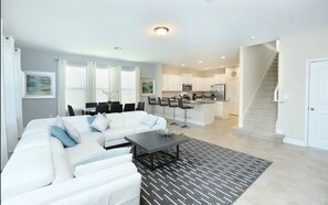 Relax in this stylish living space with a central seating area, dining nook, and modern kitchen.