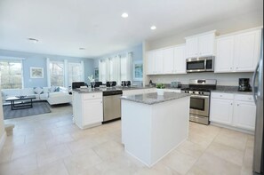 Enjoy cooking in the well-equipped kitchen with a central island, stainless steel appliances, and ample storage.
