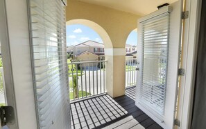 Enjoy the view from this balcony with a metal railing, offering a glimpse of the surrounding residential area.