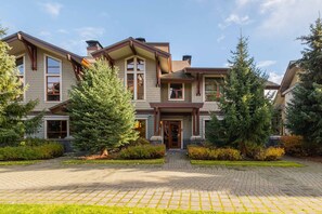 A two-story house with a brick facade, large windows, and a front porch.