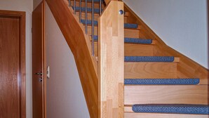 A wooden staircase with blue non-slip treads and a door on the left. - Awesome home in Neubrandenburg with WiFi (Neubrandenburg)