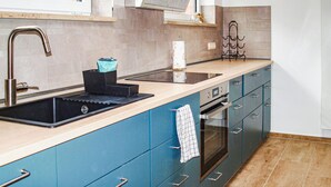 A kitchen with a double sink, a stove, and blue cabinets. - Awesome home in Neubrandenburg with WiFi (Neubrandenburg)
