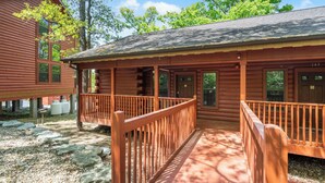 A log cabin with a covered porch and a wooden fence.