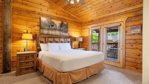 A wooden cabin bedroom with a bed, nightstands, and a ceiling fan.