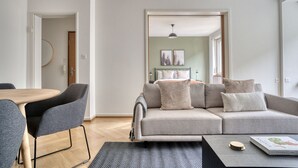A modern living room with a grey sofa, a wooden dining table, and a black coffee table. - Sunny St. Alban  3 Room w/ Storage, nr Train Station, by Blueground (Basel)