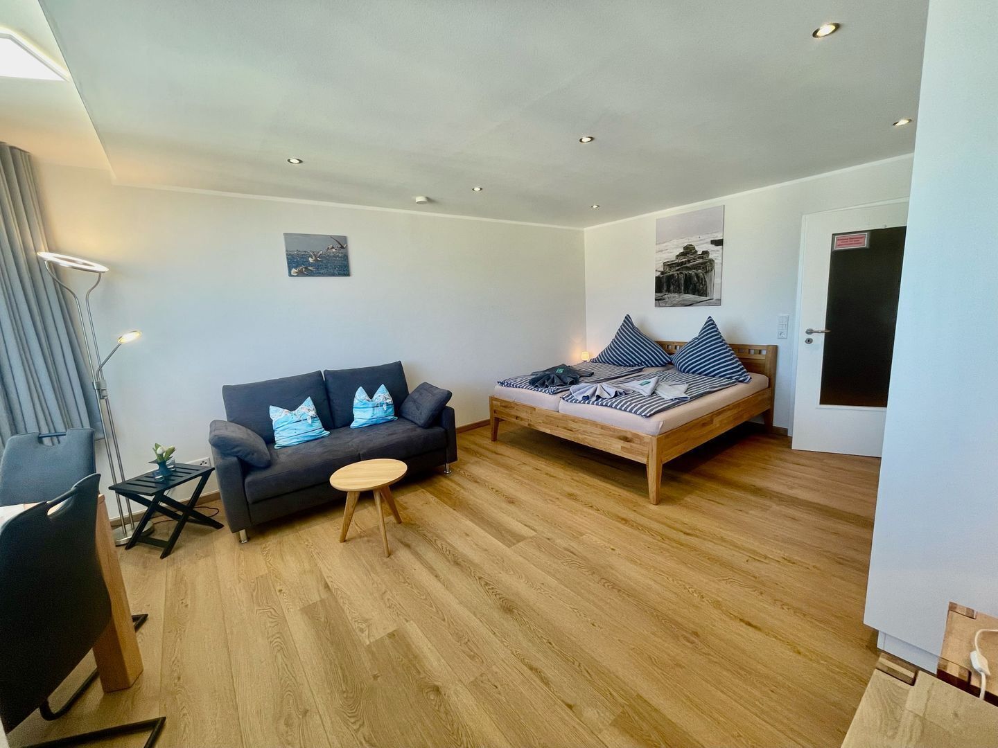Un salon moderne avec un canapé, un lit et une petite table.