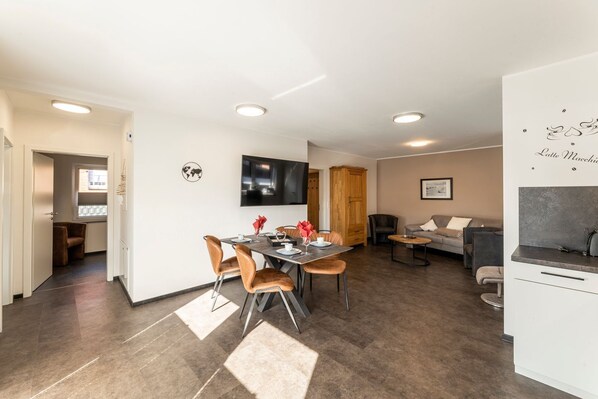A modern interior with a dining area, a sofa, and a kitchen.