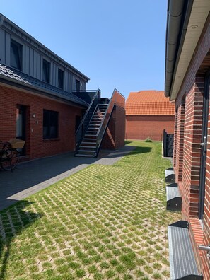 Un patio con un edificio de ladrillo, una escalera y una bicicleta.