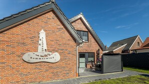 A brick building with a sign reading "Sommerwind" and a covered outdoor seating area. - Sommerwind Alfonso Borkum apartment 3 - Vacation with dog - Sommerwind Alfonso (Borkum)