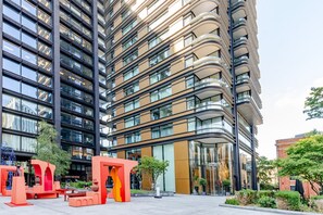 Un immeuble moderne de grande hauteur, doté de nombreux balcons et de grandes fenêtres.