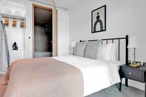 Une chambre bien rangée, avec un lit, une table de chevet et une armoire.