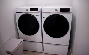 Two front-loading washing machines are conveniently stacked in this room.