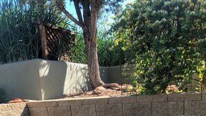 Un patio con dos sillones de descanso y una pequeña mesa.