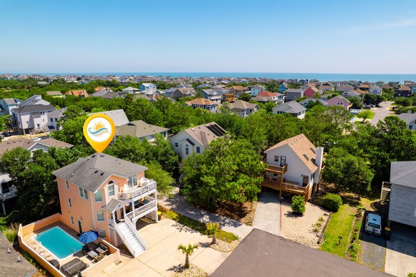 A residential area with houses, a swimming pool, and a view of the ocean. - The Silly Geese: Pool Hot Tub Games, Walk to Beach (Corolla)