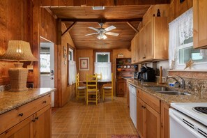 Enjoy meals in this kitchen with a central island, dining table, and modern appliances.