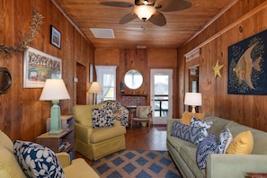 Cozy cabin-style room with a central fireplace, comfortable seating, and rustic charm.