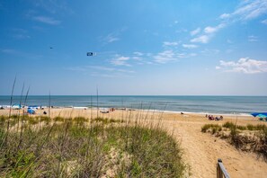 A beach with people, tents, and a clear sky.