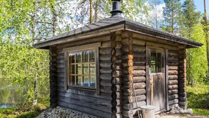 A rustic log cabin with a chimney, large windows, and a stone foundation. - Vacation home Ainola by Interhome (Joutsa)