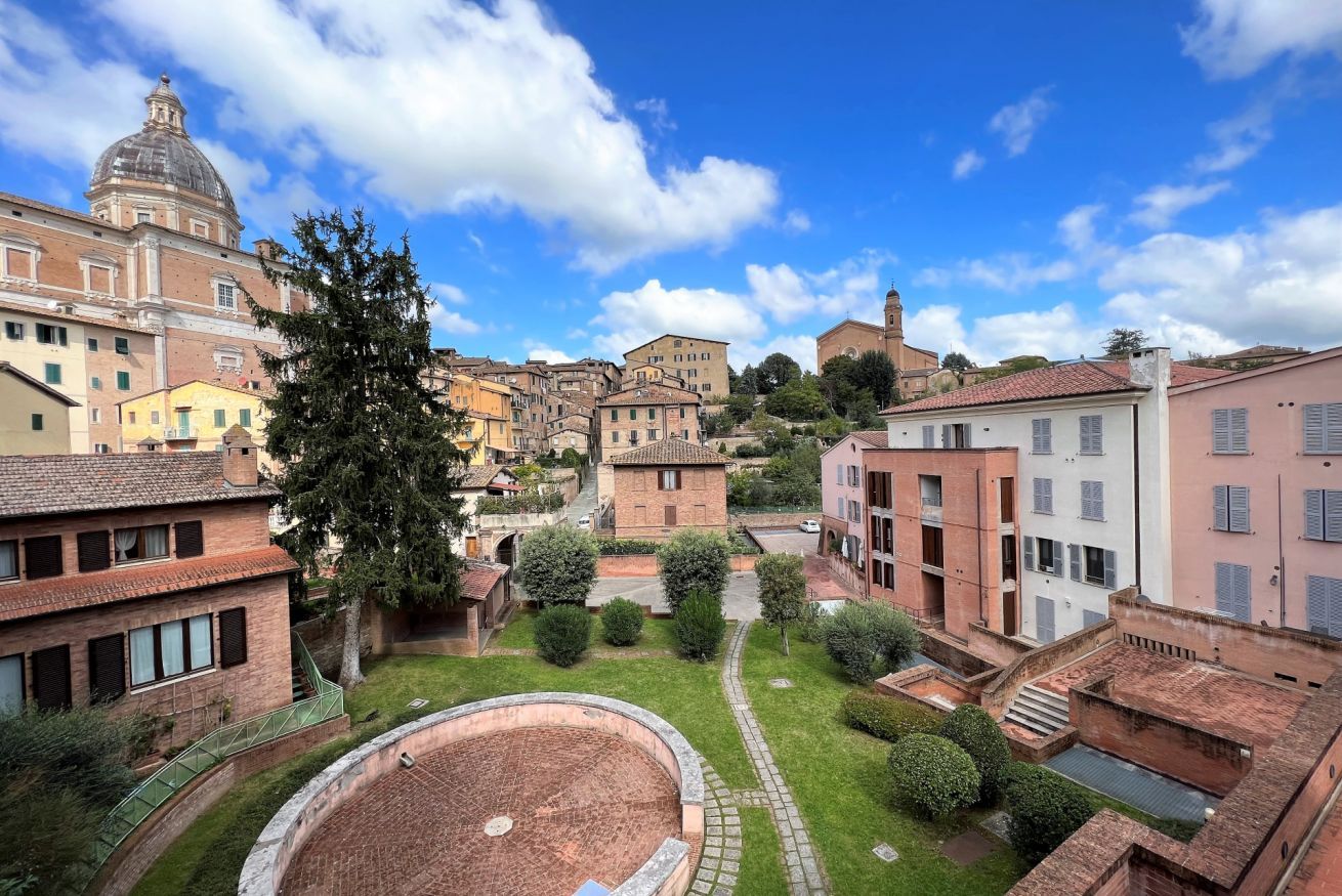 A historic town with a central square, traditional buildings, and a prominent church with a dome.