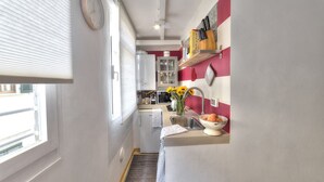 A compact kitchen with a refrigerator, sink, and a small countertop. - Santo Spirito Romantic by Mmega (Firenze)