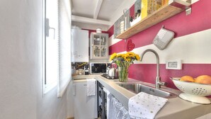 A compact kitchen with a refrigerator, microwave, sink, and a small dish rack. - Santo Spirito Romantic by Mmega (Firenze)