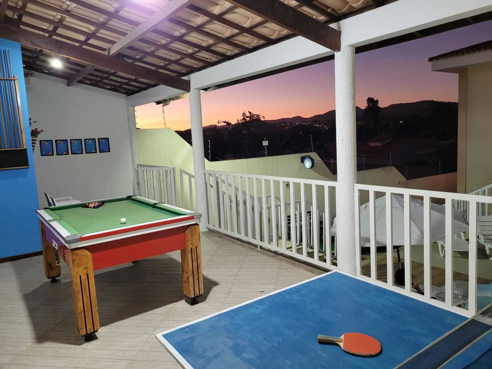 An outdoor pool area with a pool table and a ping pong table.
