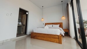 A modern bedroom with a wooden bed, two pendant lights, a large window, and a view of the outdoors. - Dana's House (Tabanan)