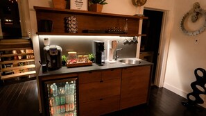 Une cuisine compacte équipée d’une machine à café, d’un grille-pain et d’un réfrigérateur.