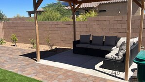 Un patio con sofá integrado y una estructura de pérgola.