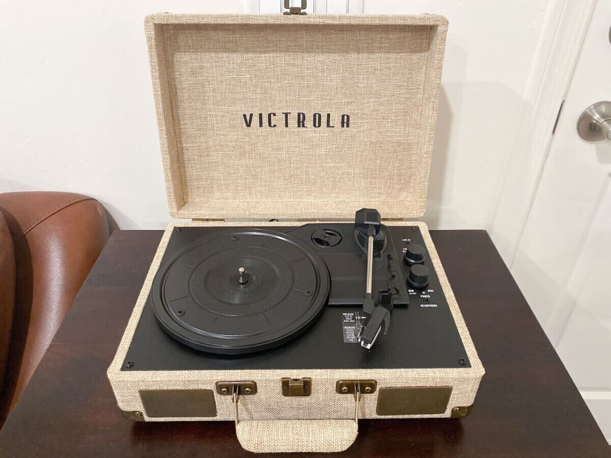 Une platine vinyle dans un boîtier de style rétro, avec le nom de la marque « VICTROLA » visible sur le couvercle.