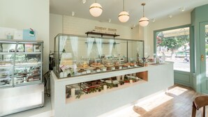 A bakery counter with pastries and a sign reading "Sunday Baker". - Lanna Bonita Boutique Hotel (Chiang Mai)