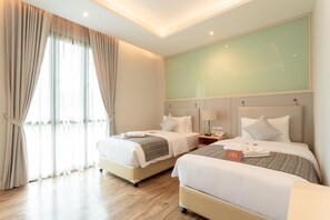 A hotel room with two beds, a large window with curtains, a flat-screen TV, and a wooden floor. - Lanna Bonita Boutique Hotel (Chiang Mai)