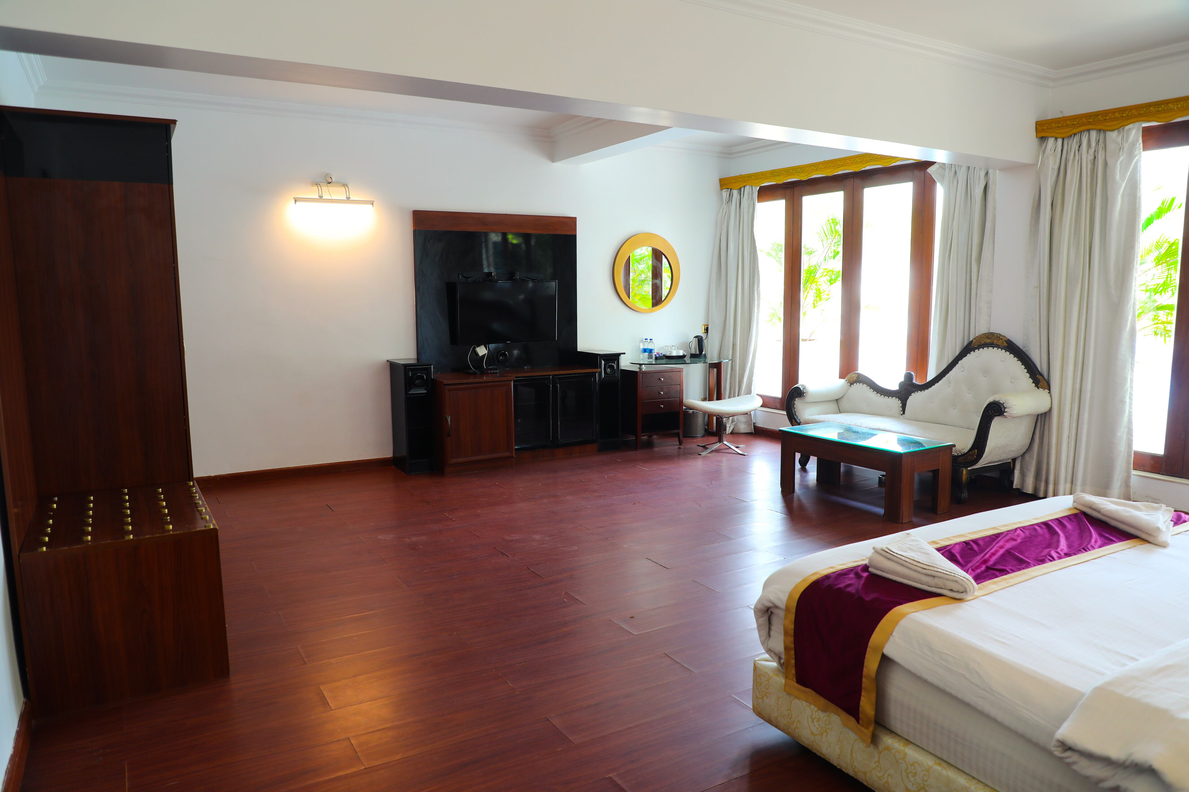 Une chambre d’hôtel comprenant un lit, un bureau, une chaise, une télévision et une armoire.