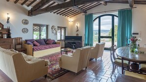 Un soggiorno accogliente con divano, poltrone, un pianoforte e un tavolo da pranzo.