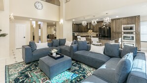 A spacious living room with a large sectional sofa, a coffee table, and a patterned rug. - Beautiful and Very Spacious house 6 bed/3.5 baths (Round Rock)