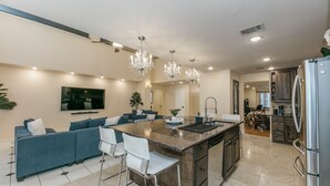 A modern kitchen with a central island, bar stools, a built-in oven, and stainless steel appliances. - Beautiful and Very Spacious house 6 bed/3.5 baths (Round Rock)