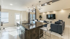 A modern kitchen with a marble island, stainless steel appliances, and a chandelier. - Beautiful and Very Spacious house 6 bed/3.5 baths (Round Rock)