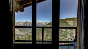 Una habitación con un amplio ventanal que ofrece vistas a la montaña.