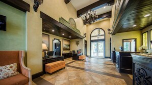 A spacious lobby with a reception desk, a sofa, a bench, and a chandelier. - Beachfront St Thomas Getaway - Family Friendly Resort Condo - Sleeps 8 (St. Thomas)