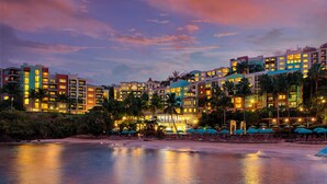 A beachfront hotel with multiple buildings, a sandy beach, and umbrellas. - Beachfront St Thomas Getaway - Family Friendly Resort Condo - Sleeps 8 (St. Thomas)